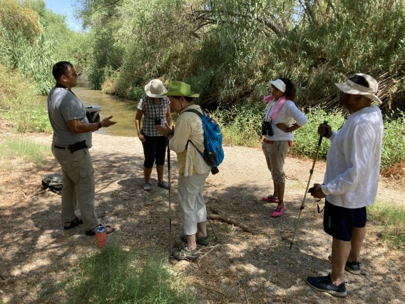 Group of people standing next to the Santa Cruz with hiking poles and hats on