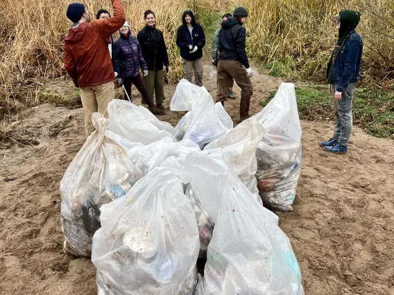 Group of people standing near white trash bags