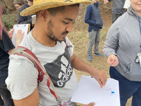 Student putting braille number stickers on braille worksheet