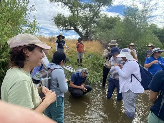 Group of people standing on edge of Santa Cruz River