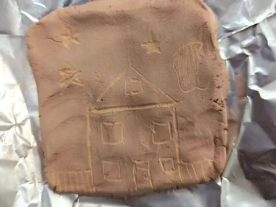 Image of student created petroglyph of house with stars