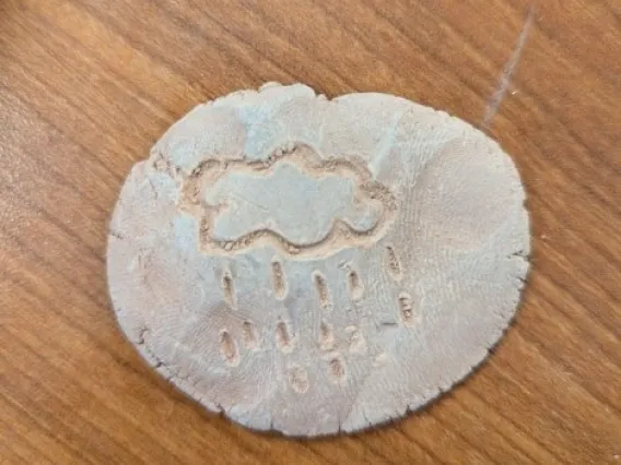 Example of student made petroglyph of cloud with rain coming out of it