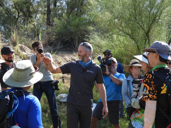 Group of people looking at a person holding a dragonfly