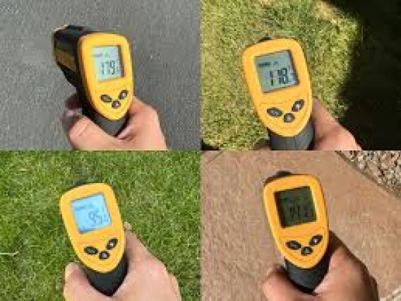 Four hands holding infrared thermometers over different types of ground cover