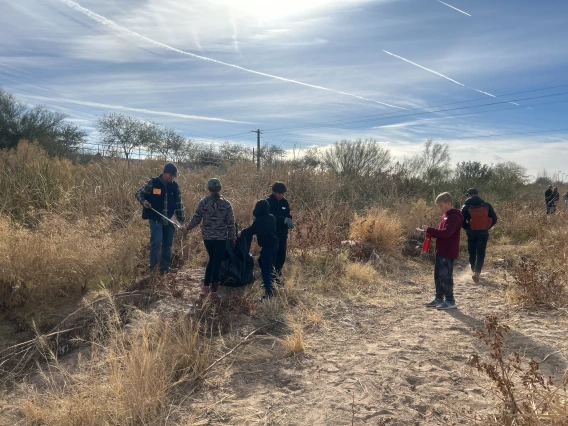 Students collecting trash and carrying bags 