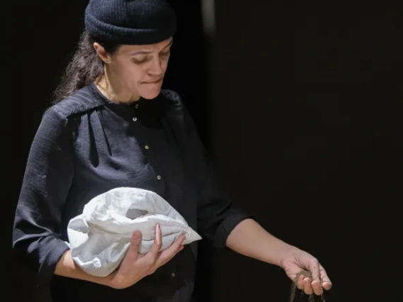 Person holding a bag and pouring sand out of her hand