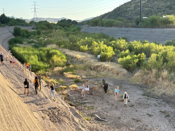 People walking in Santa Cruz River at Landing Place art installation
