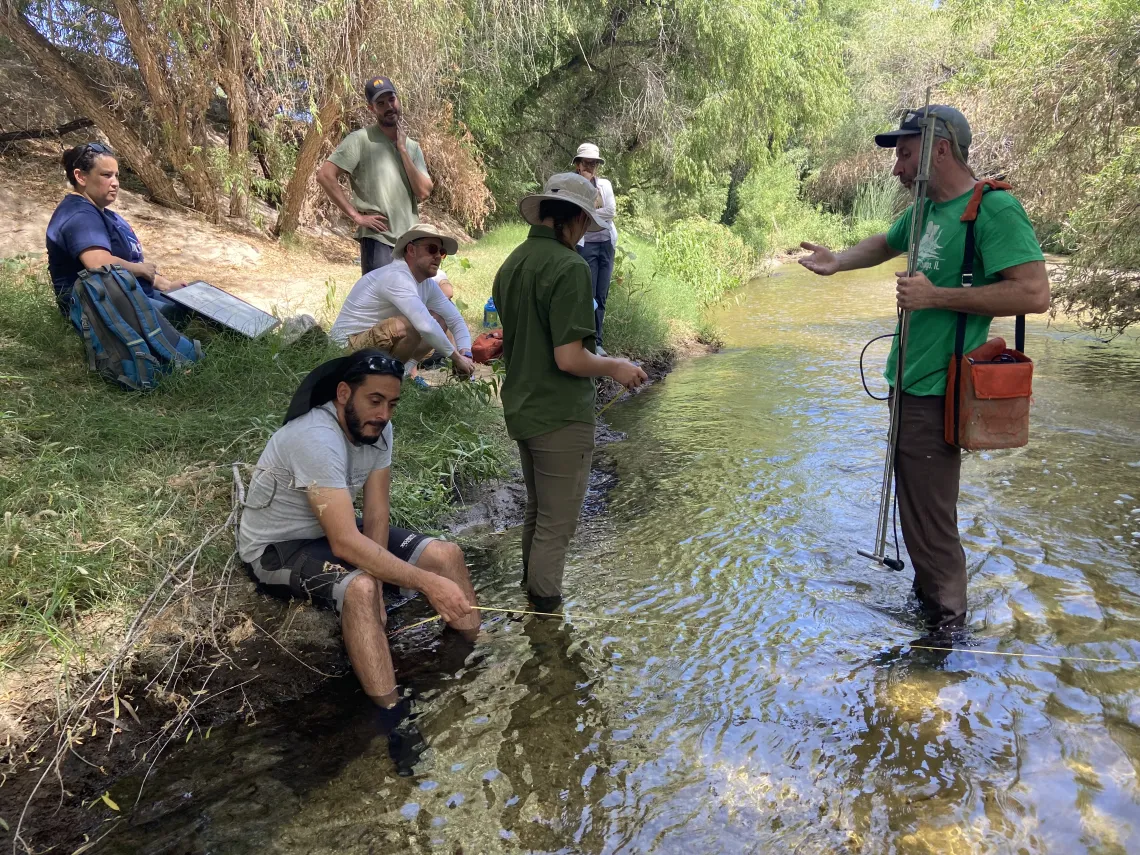 People standing in river holding measuring equipment