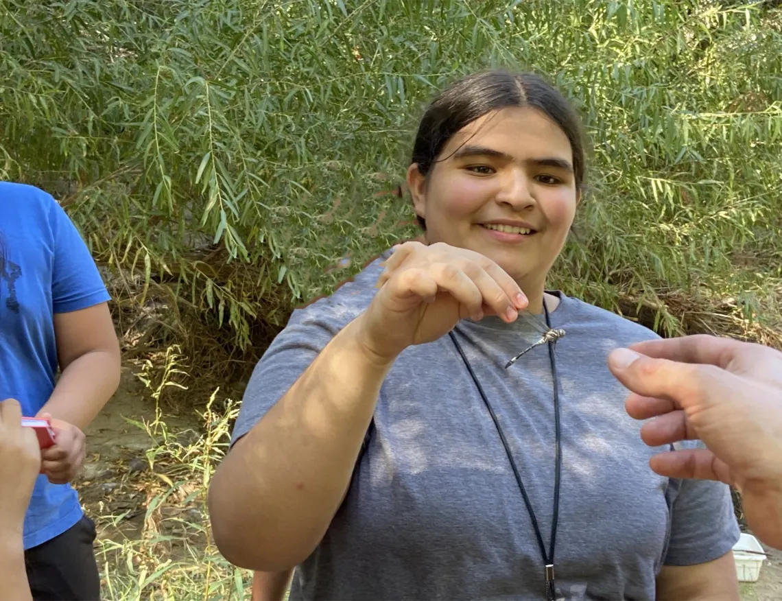 Smiling girl holding a dragonfly 