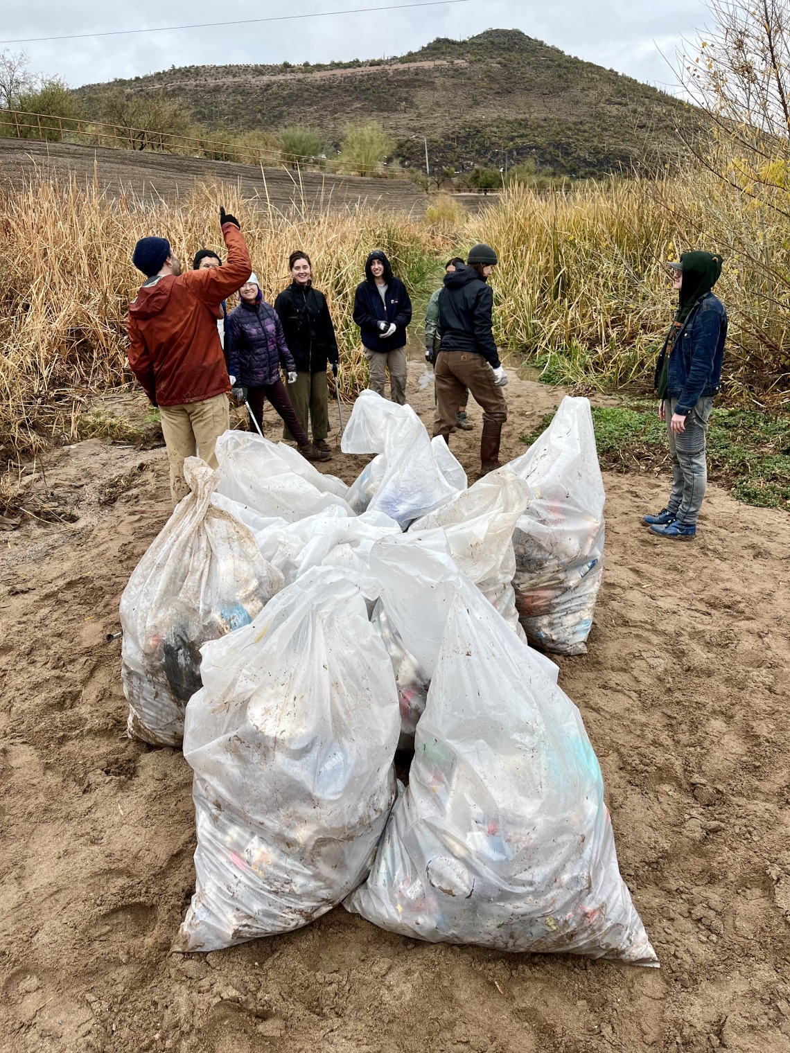 Group of people standing near white trash bags