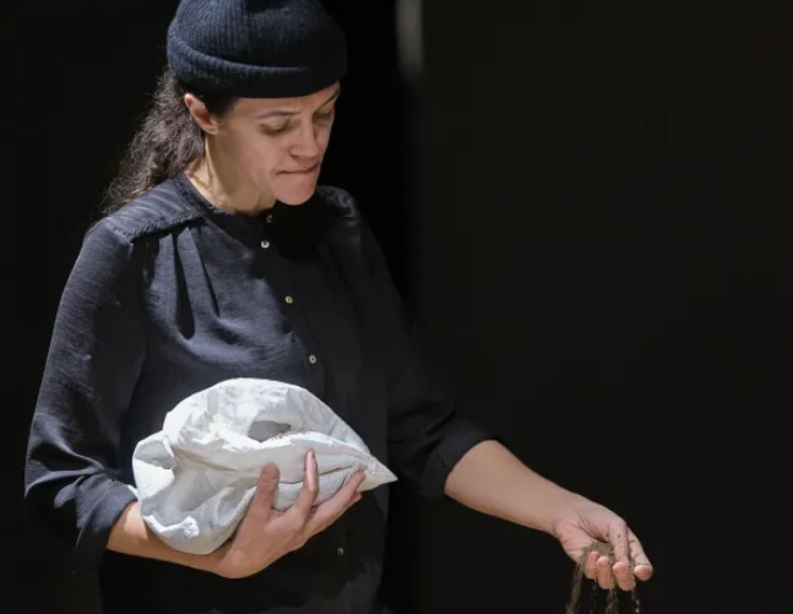 Person holding a bag and pouring sand out of her hand