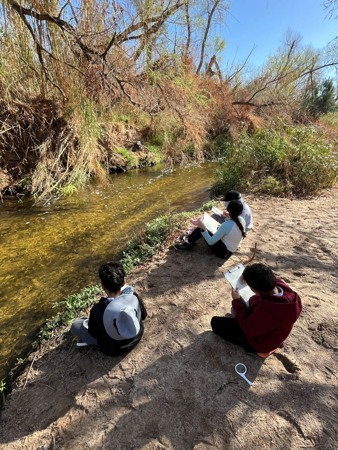 Students drawing the Santa Cruz River on a field trip