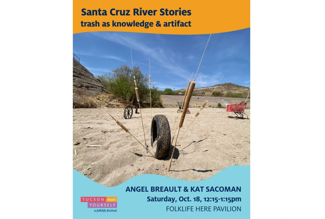 Dry portion of Santa Cruz River with tire and cat tails around it with red shopping cart in the background