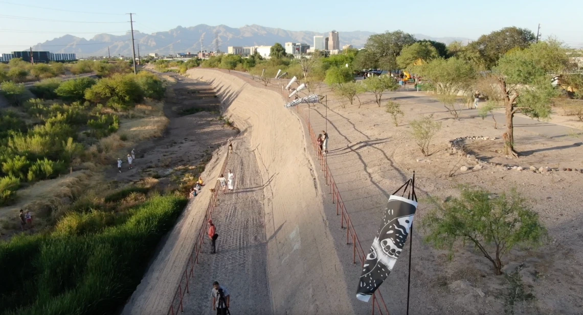 Santa Cruz River with black and white windsocks on the bank