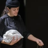 Person holding a bag and pouring sand out of her hand