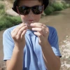 Little boy holding two damselflies, one in each hand